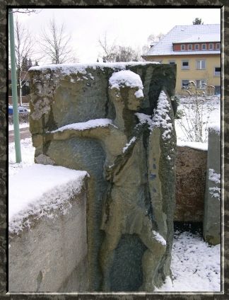Steinfigur im Labyrinth, leicht mit Schnee bedeckt